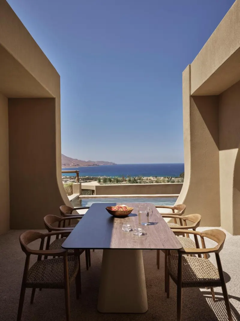 Outdoor dining table framed by concrete archway