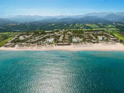 Aerial view of resort along sandy beach and mountains