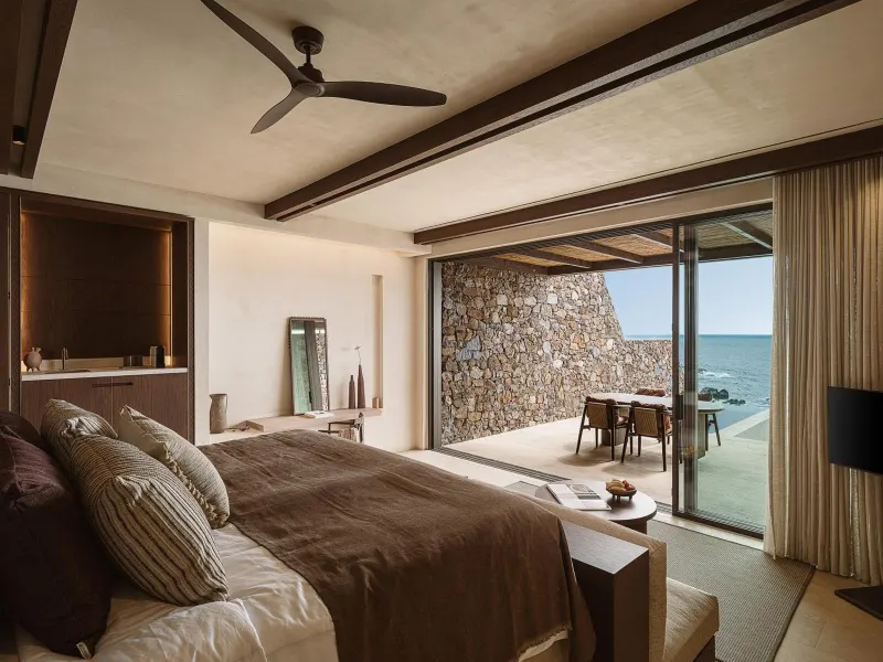 Elegant bedroom opening to stone terrace and sea