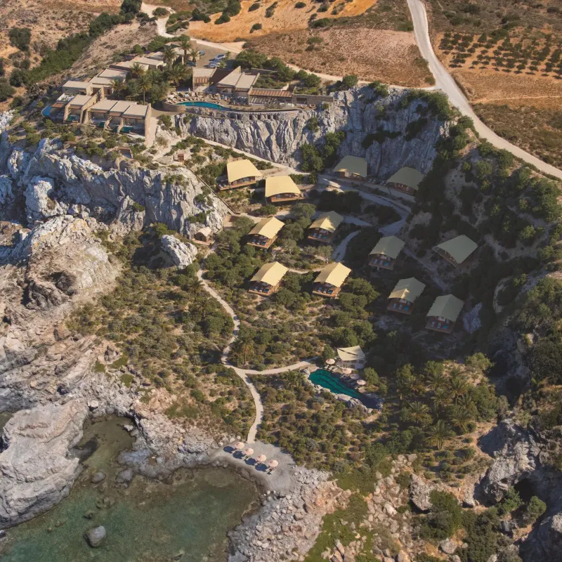 Aerial view of resort tents amid coastal cliffs