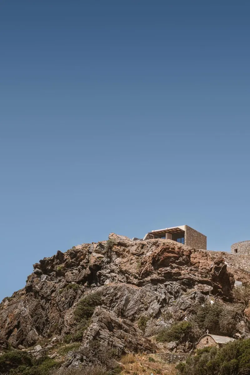 Modern building perched atop rugged rocky hill