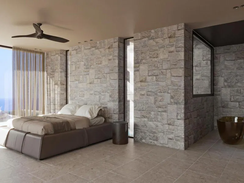 Stone-walled bedroom with ceiling fan and bed