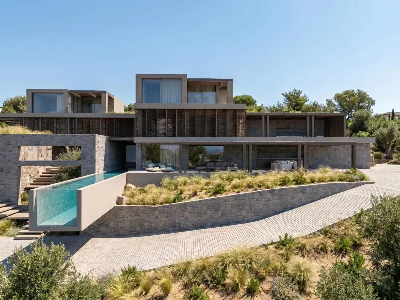 Villa exterior with glass pool edge and hillside view