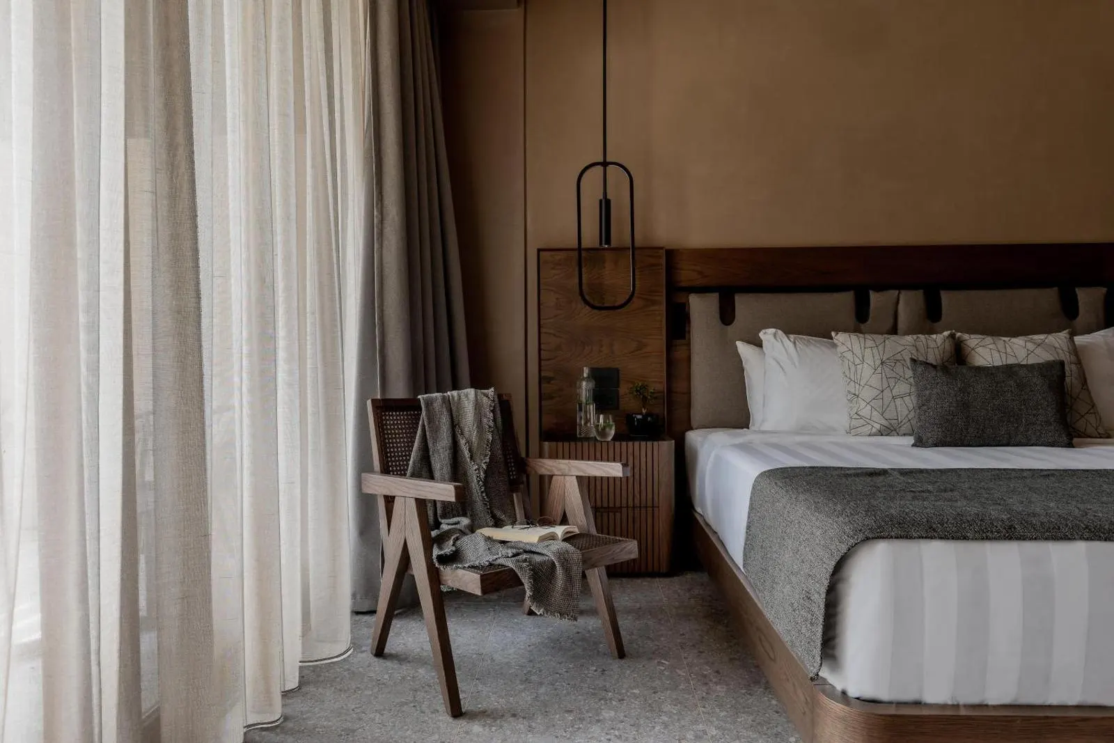 Bedroom with sheer curtains and wooden armchair