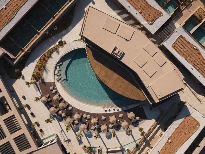Aerial view of curved rooftop pool and lounge area