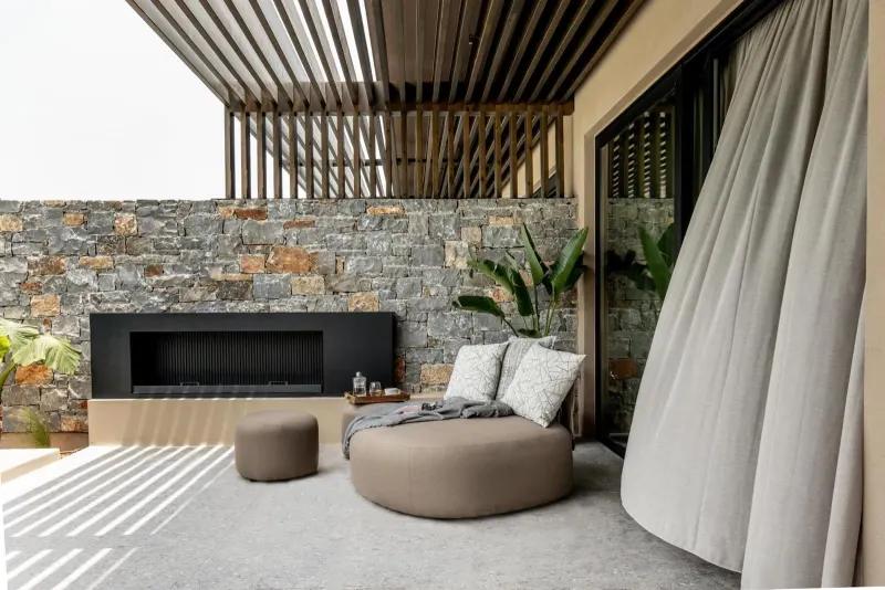 Outdoor lounge with fireplace and stone wall