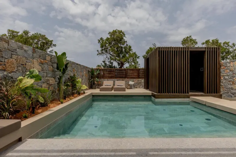 Rectangular pool surrounded by stone walls and plants