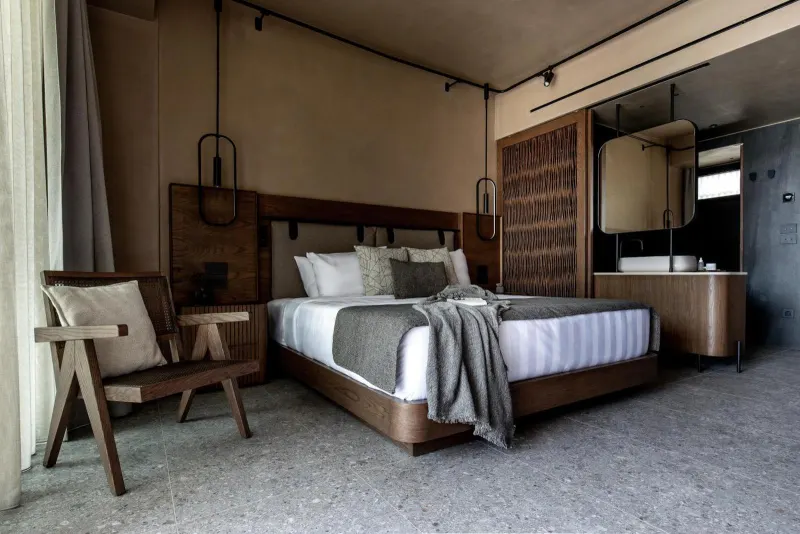 Bedroom with wooden headboard and open bathroom