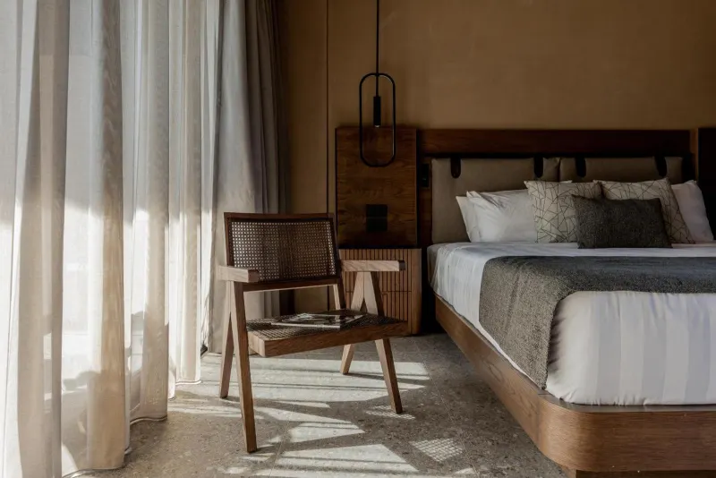 Sunlit bedroom with sheer curtains and armchair