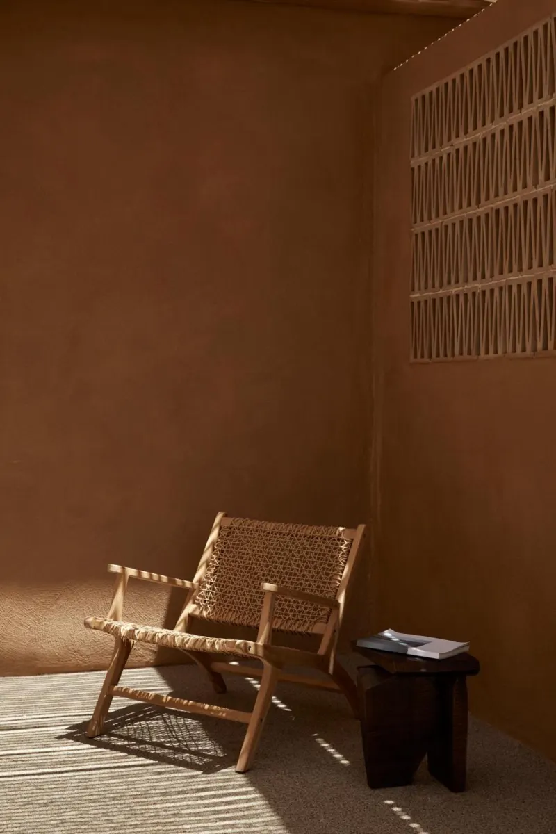 Rattan lounge chair in warm-toned corner nook