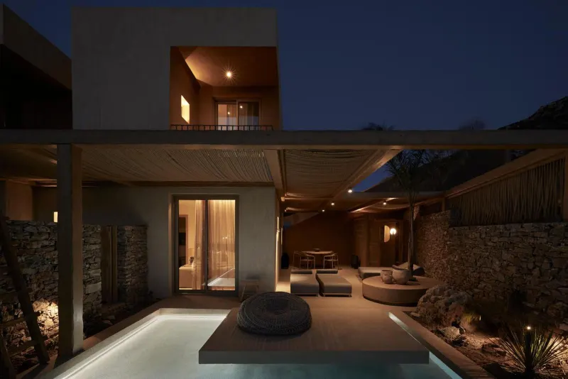Modern building exterior with pool lit at dusk