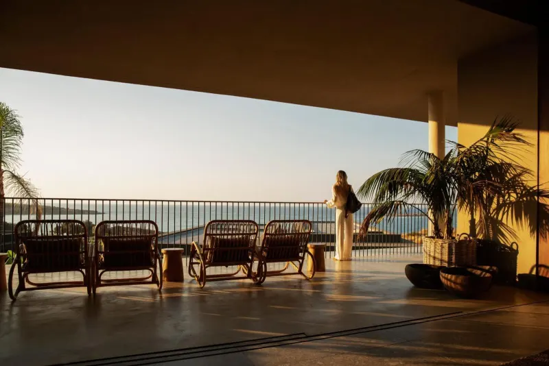 Person admiring sunset view from covered terrace