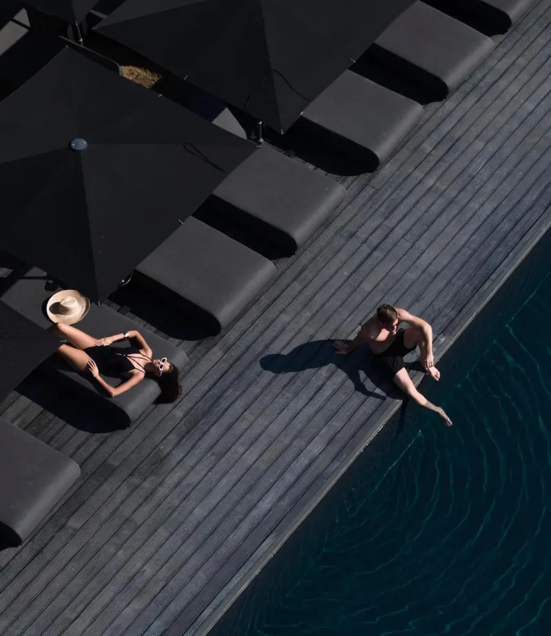 Aerial view of two people relaxing by pool