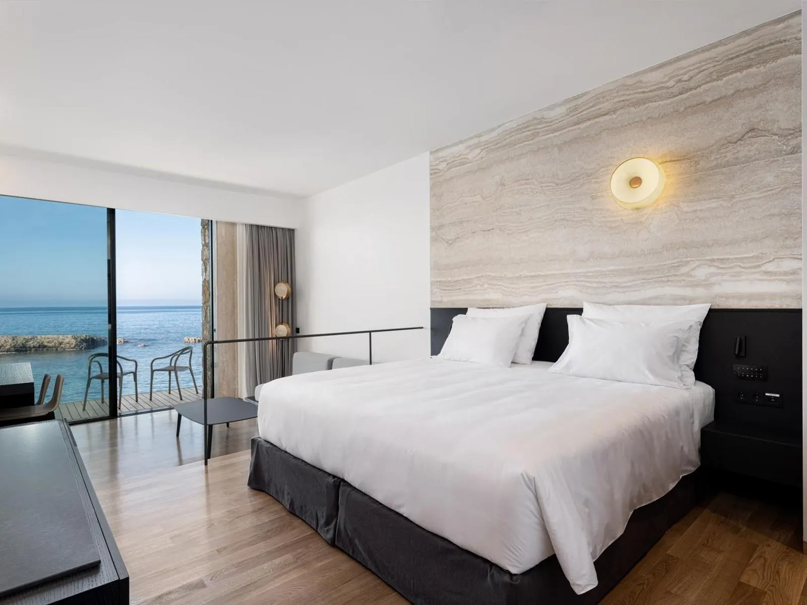 Bedroom with sea view balcony and white bedding