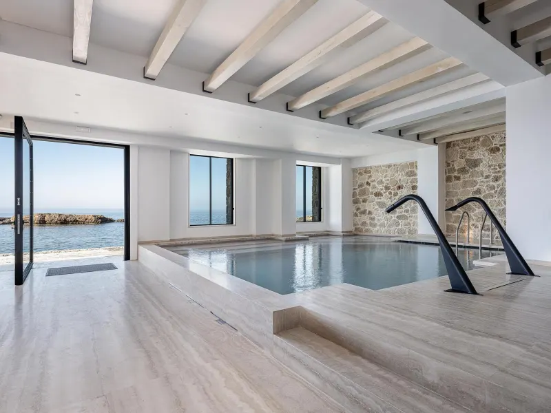 Indoor pool with large windows facing the sea