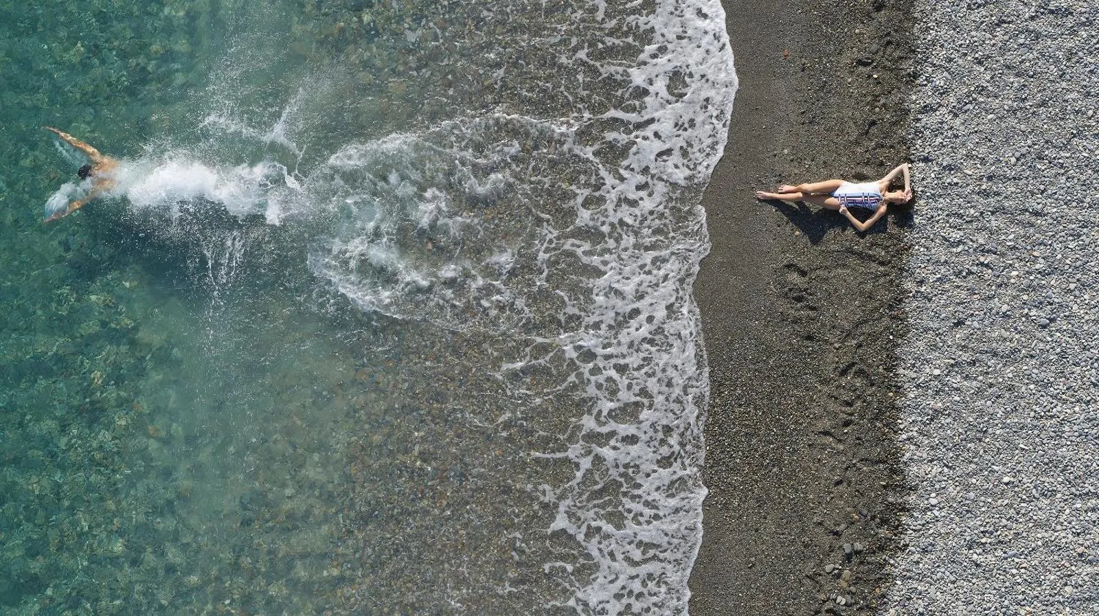 Aerial view of swimmer and sunbather on beach