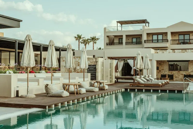 Pool deck with lounge chairs and hotel building