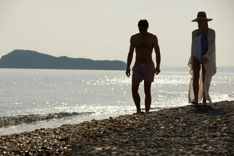 Silhouette of couple walking along beach shoreline
