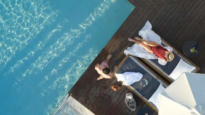 Aerial view of couple lounging by pool edge