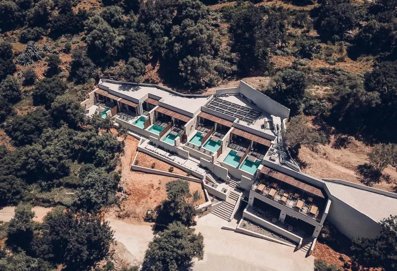 Aerial view of hillside hotel with private pools