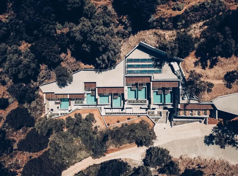 Aerial view of resort building with pools and trees