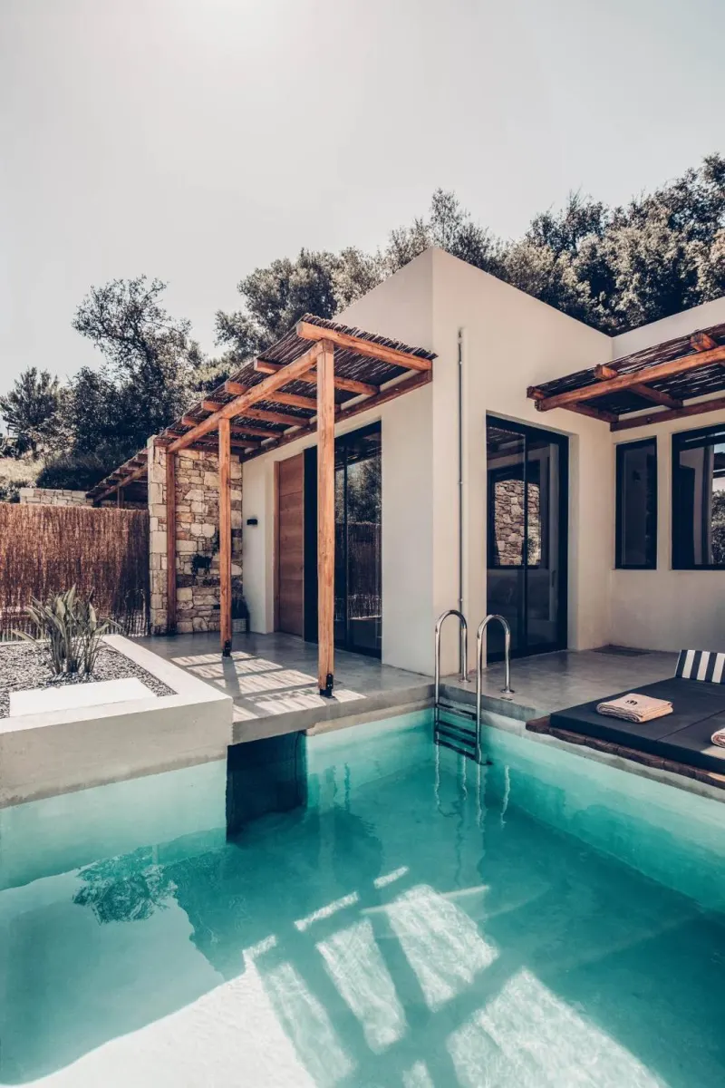 Private pool with wooden pergola and stone walls