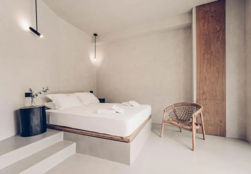 Minimalist bedroom with pendant lights and wooden chair