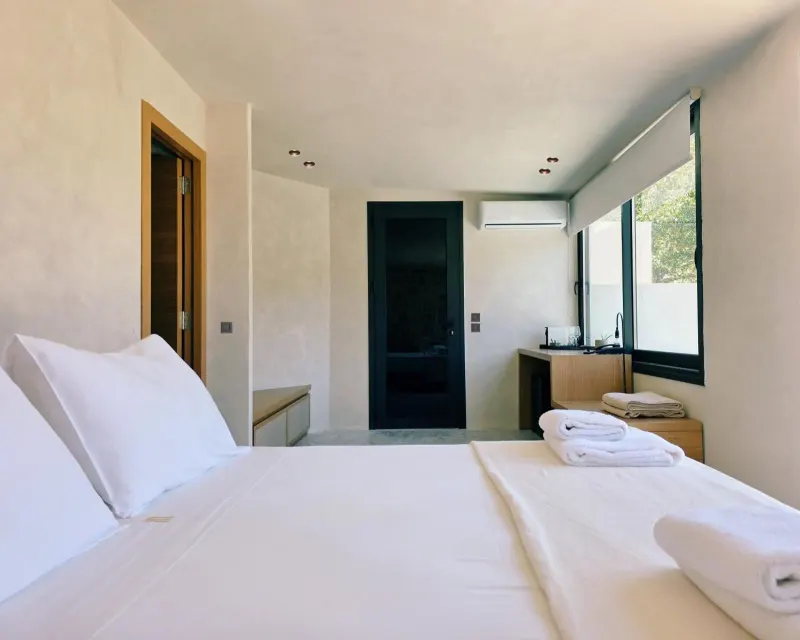 Bedroom with white linens and wooden accents