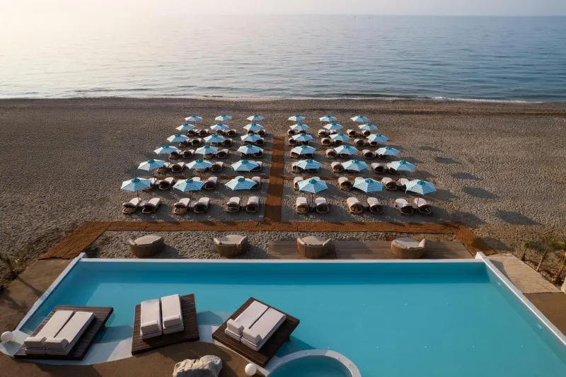 Aerial view of pool loungers facing the beach