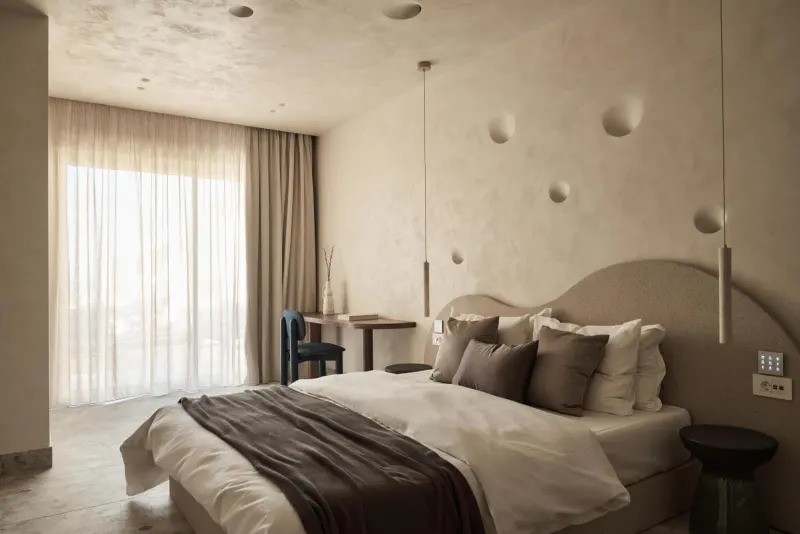 Bed with pendant lights and curtained window