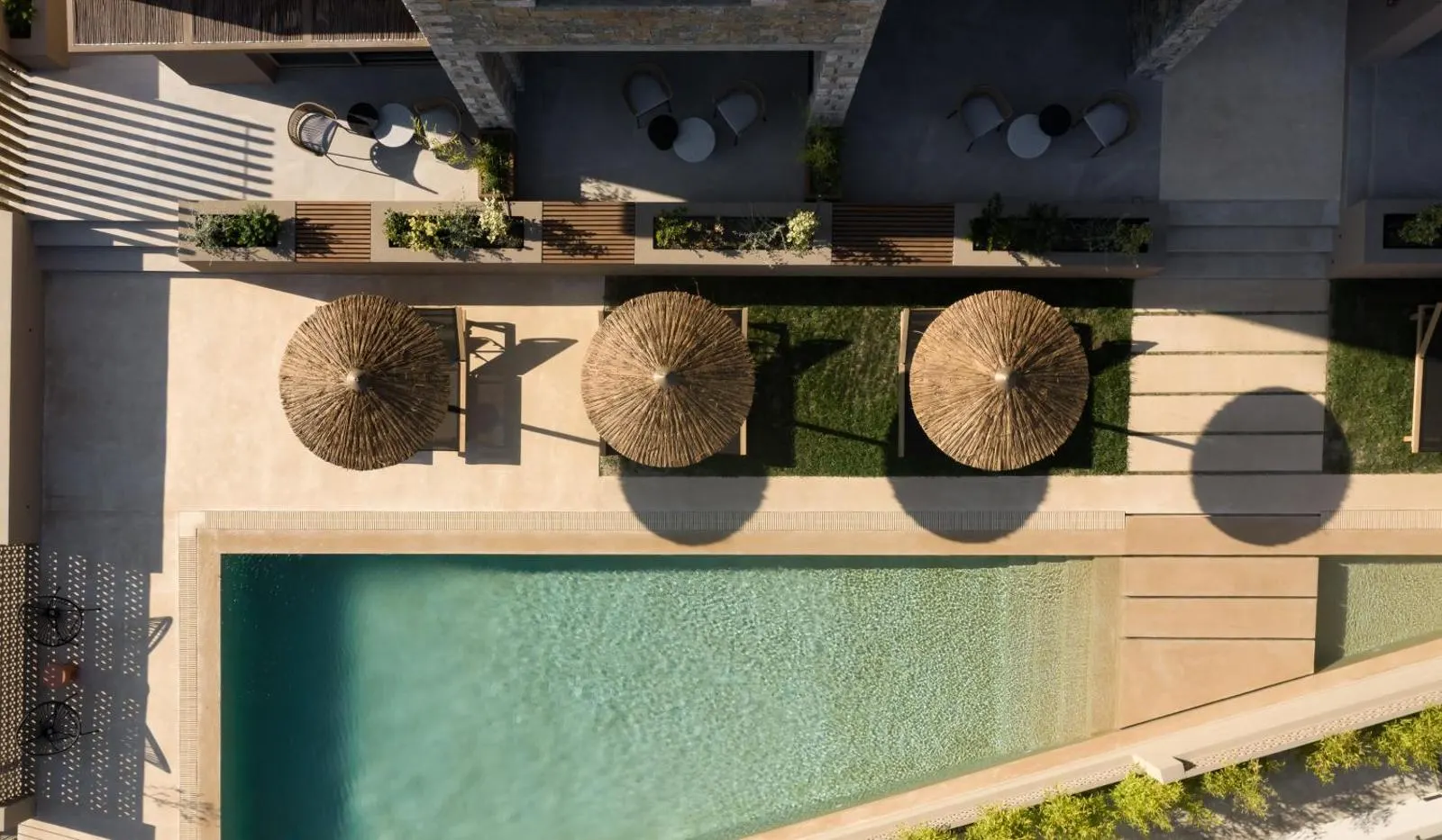 Aerial view of pool with straw umbrellas