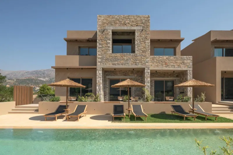 Stone villa exterior with pool and loungers