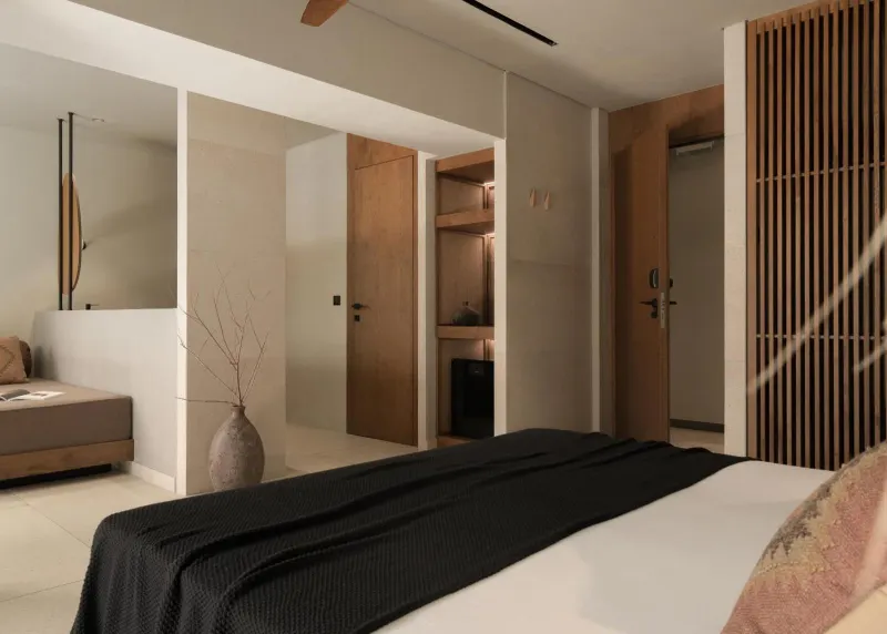 Bedroom with black bedding and wood slat door