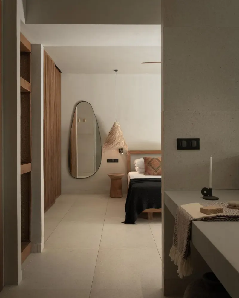 Hallway view into bedroom with oval mirror