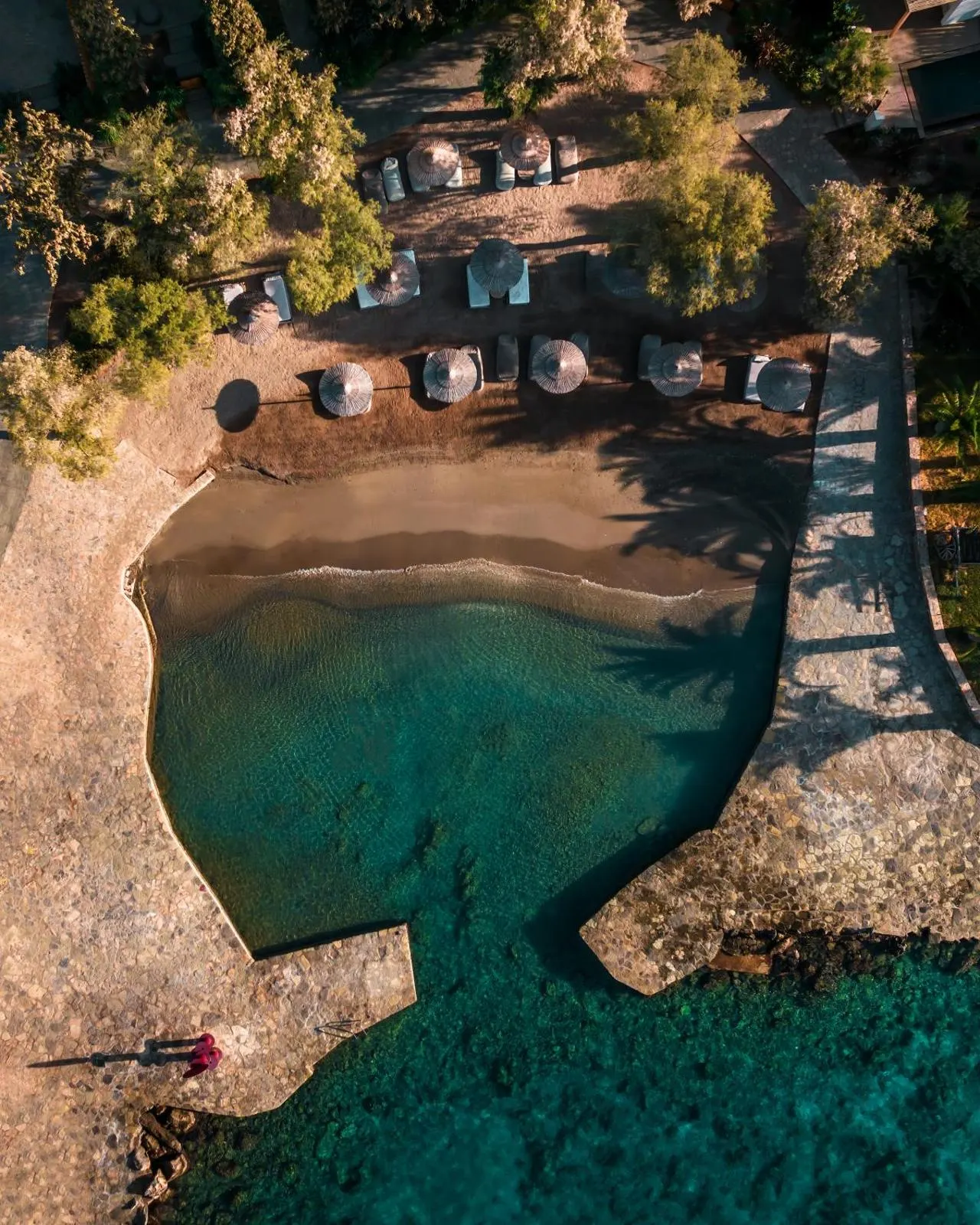 Aerial view of private cove beach with umbrellas