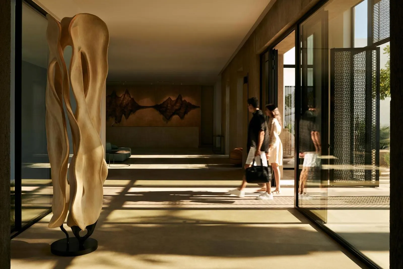 Guests walking through modern lobby with sculpture