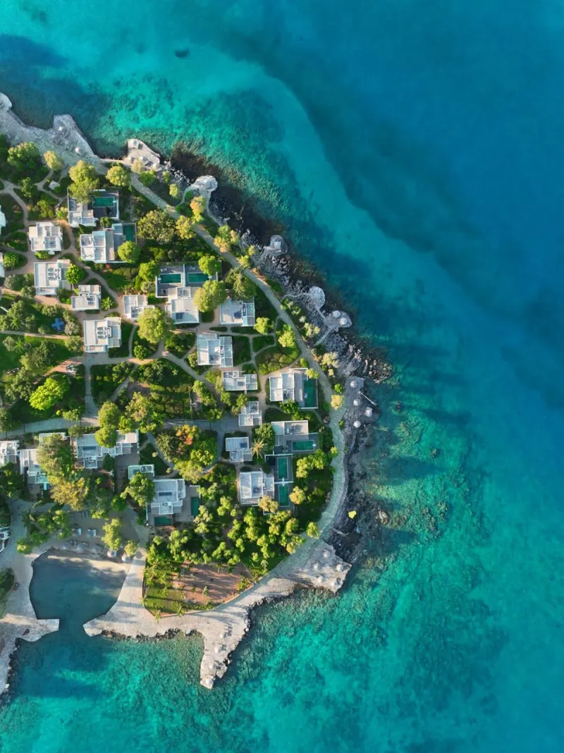 Aerial view of coastal resort peninsula with pools