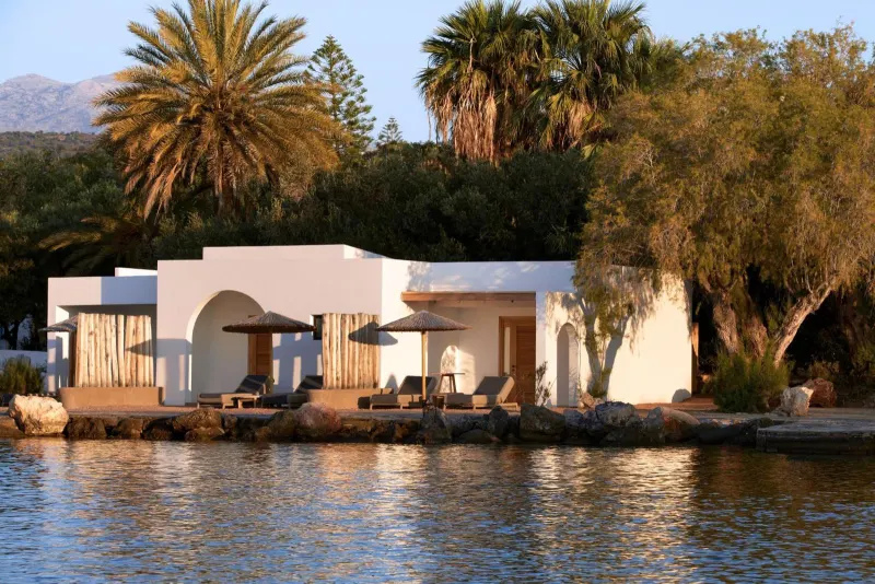Whitewashed villa by the water at sunset