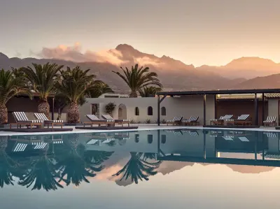 Sunset view of pool with mountains and palm trees