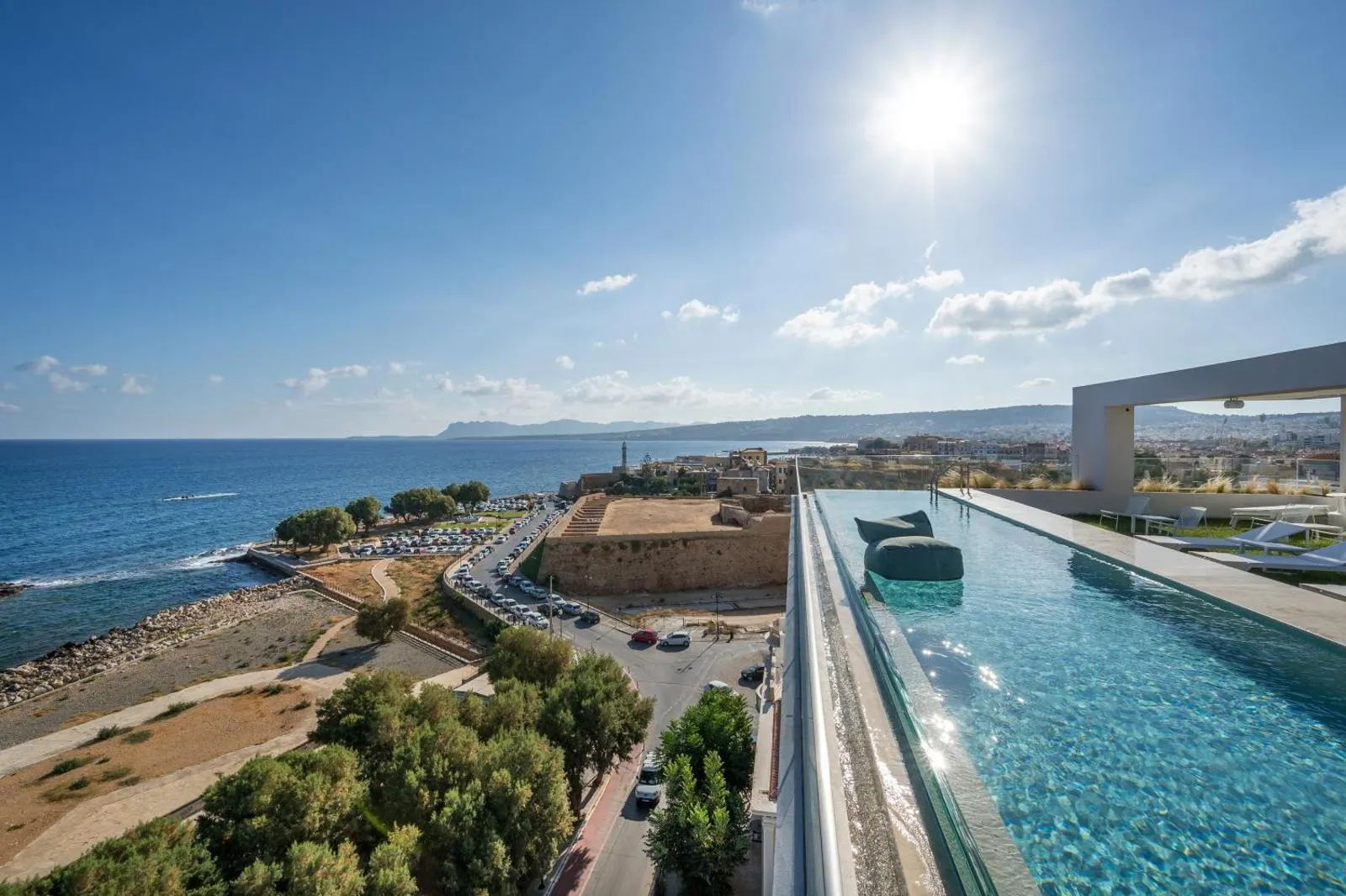 Rooftop pool overlooking coastal fortress and city skyline