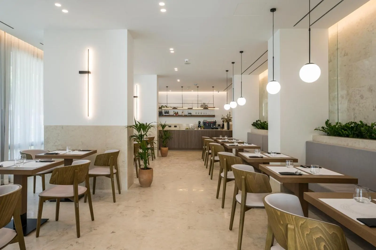Bright modern hotel restaurant with wooden chairs