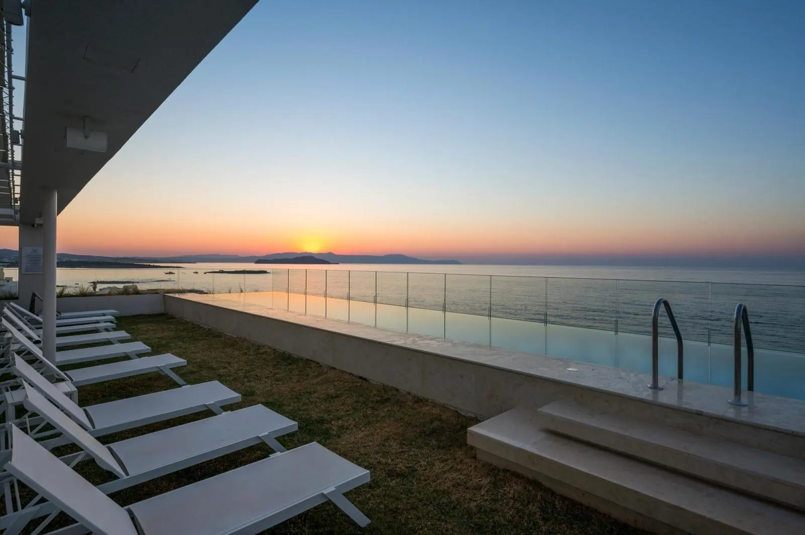 Sunset view from rooftop terrace loungers by pool
