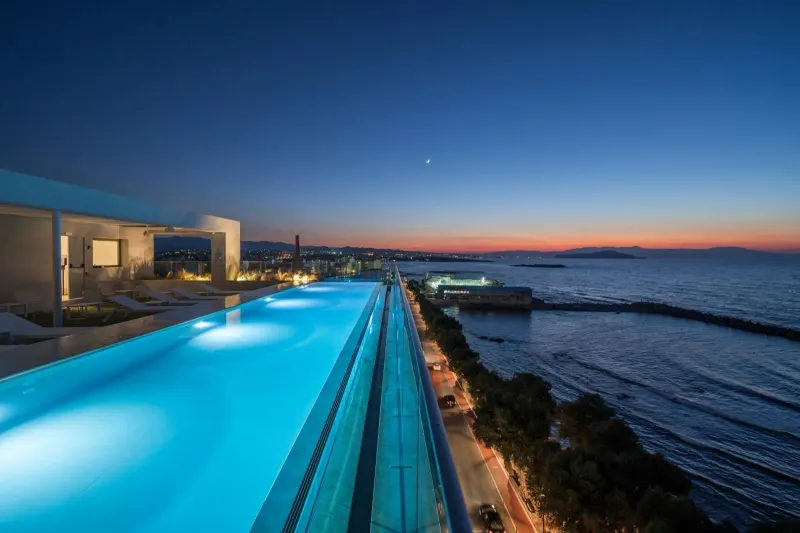 Rooftop pool glowing blue against night sky