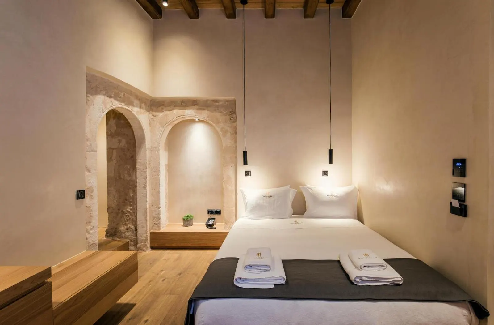 Bedroom with exposed stone archway and pendant lights