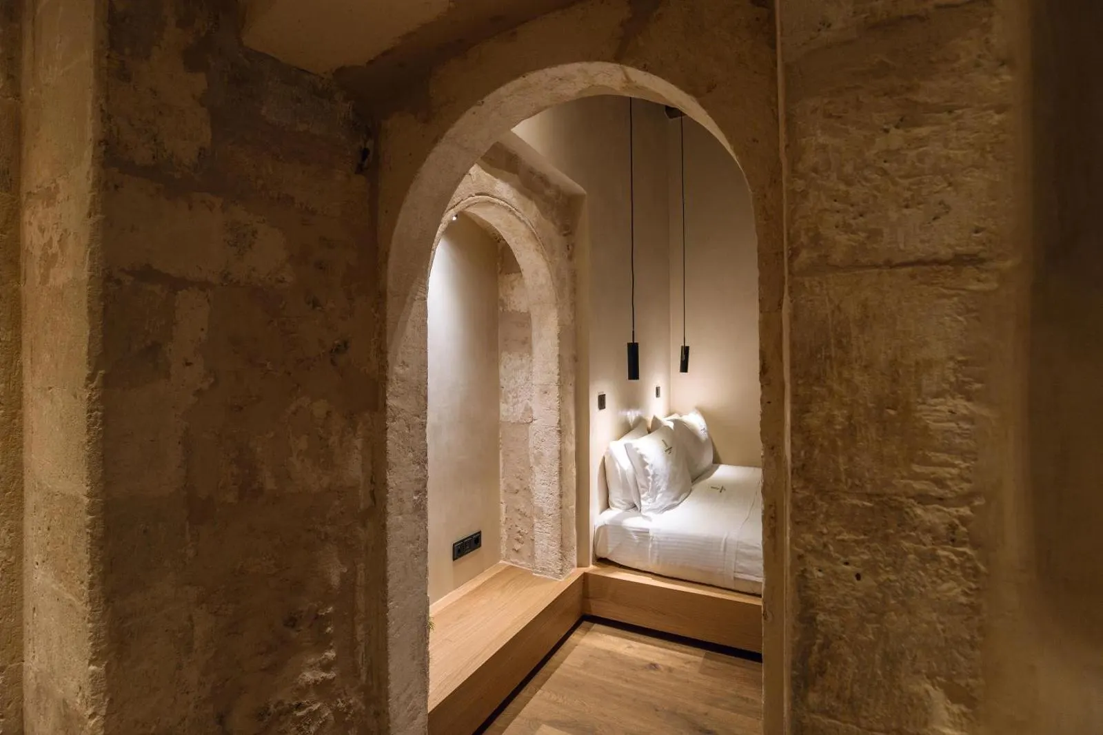 Stone archway hallway leading to bed nook