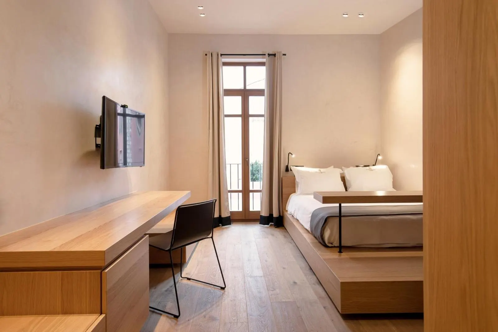 Minimalist bedroom with desk and balcony door