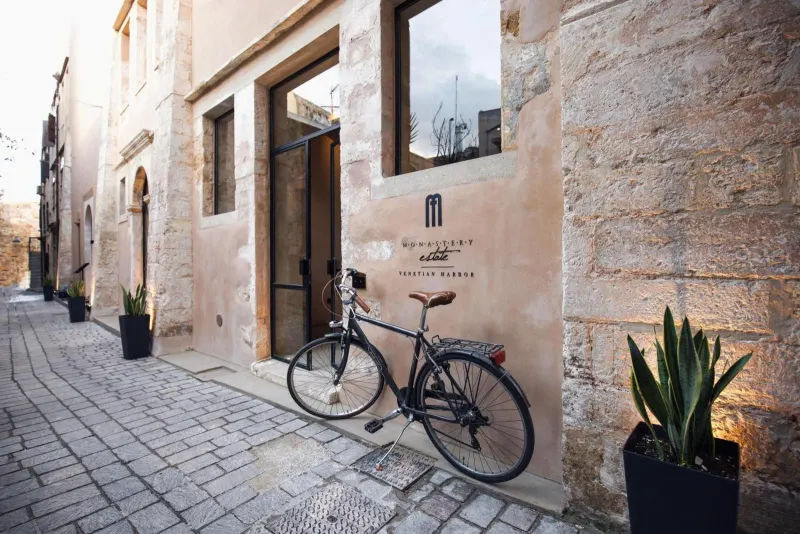 Bicycle parked outside hotel entrance with plants