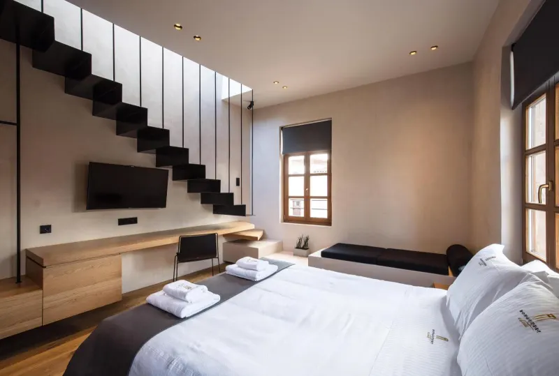 Twin beds beneath staircase in modern room