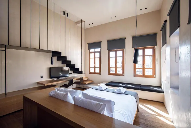 Loft-style room with windows and low bed