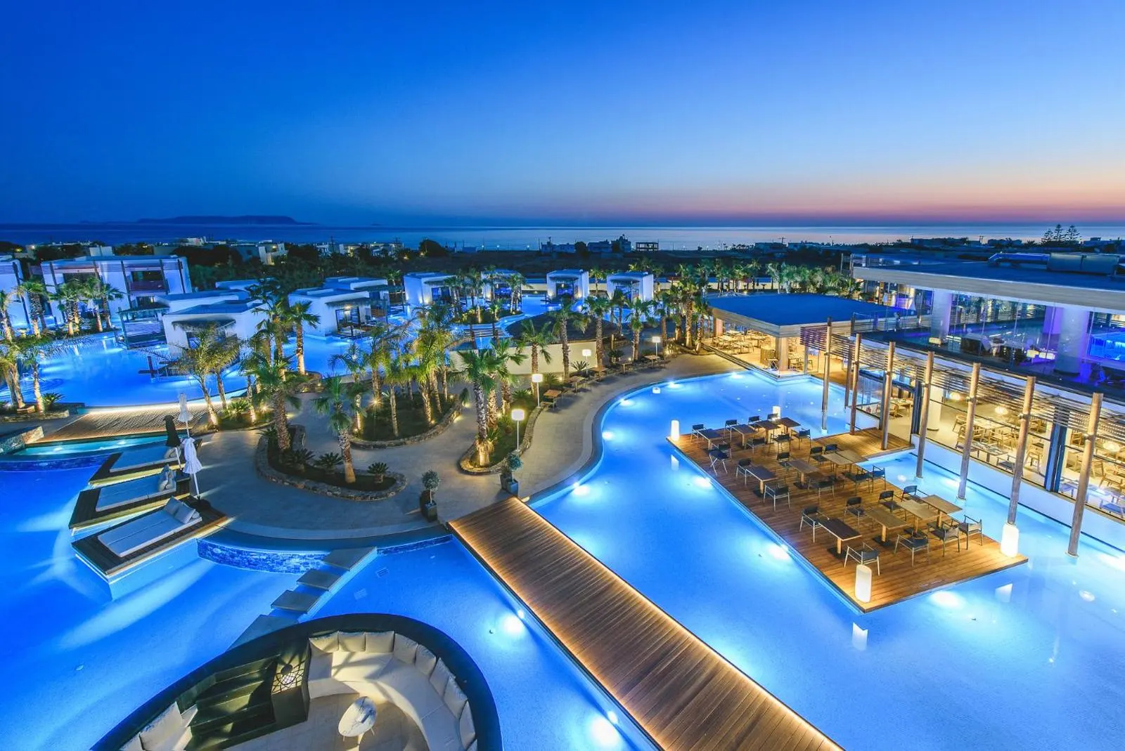 Twilight view of resort pools with illuminated walkways